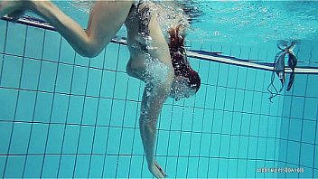 Redheaded Katrin is stripping underwater